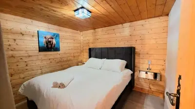 a bedroom with a bed in a wooden wall at Ski in Ski out MNT Direct piste access in Les Houches