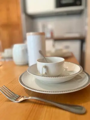 a cup on a plate on a table with a fork at Entre amis-Résidence La Piste Bleue-Ski aux pieds in Saint-Gervais-les-Bains