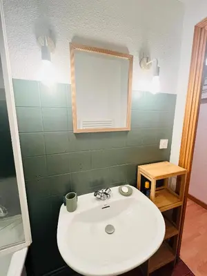 a bathroom with a white sink and a mirror at Entre amis-Résidence La Piste Bleue-Ski aux pieds in Saint-Gervais-les-Bains