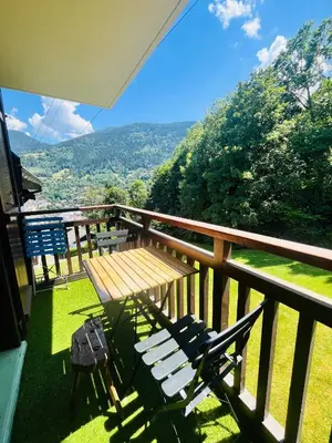 a balcony with a wooden table and a bench at Entre amis-Résidence La Piste Bleue-Ski aux pieds in Saint-Gervais-les-Bains