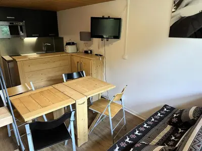 a room with a table and a kitchen with a television at Chalets Autrichiens - T2/4PAX - CHALETS AUTRICHIENS MAE-3263 in Megève