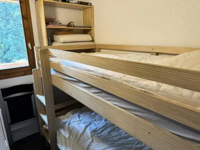 two bunk beds in a room with a window at Chalets Autrichiens - T2/4PAX - CHALETS AUTRICHIENS MAE-3263 in Megève