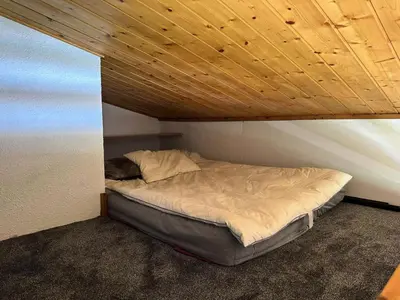 a bed in a room with a wooden ceiling at Chalets Autrichiens - T2/4PAX - CHALETS AUTRICHIENS MAE-3263 in Megève