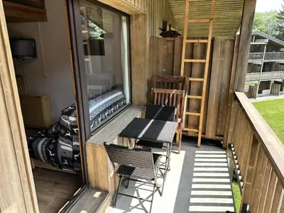 a patio with chairs and a table on a balcony at Chalets Autrichiens - T2/4PAX - CHALETS AUTRICHIENS MAE-3263 in Megève