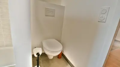 a small bathroom with a toilet in a white wall at Le Sève - B103 in Samoëns
