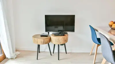 a living room with a table with a tv at Le Sève - B103 in Samoëns