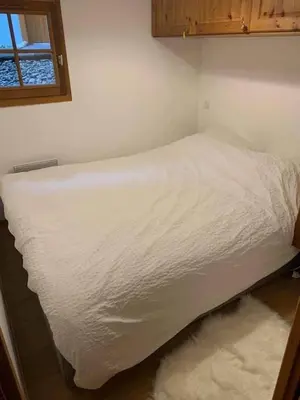 a white bed in a room with a window at Contamines-Monjoie in Les Contamines-Montjoie