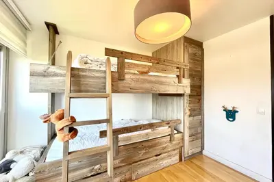 a bedroom with a bunk bed with a ladder at Le Repère de l'Ours in Megève