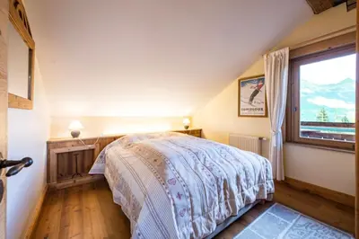 a bedroom with a bed and a window at Accommodation of 167 m2 with views of Mont Blanc in Combloux