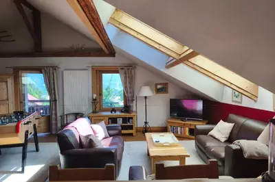 a living room with couches and a tv at Accommodation of 167 m2 with views of Mont Blanc in Combloux