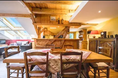 a dining room with a wooden table and chairs at Accommodation of 167 m2 with views of Mont Blanc in Combloux