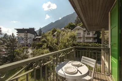 a balcony with a table and chairs and mountains at Blanc Neige in Chamonix-Mont-Blanc