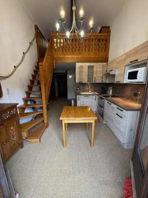 a kitchen with a wooden table and a staircase at Le chalet des pistes in Demi-Quartier