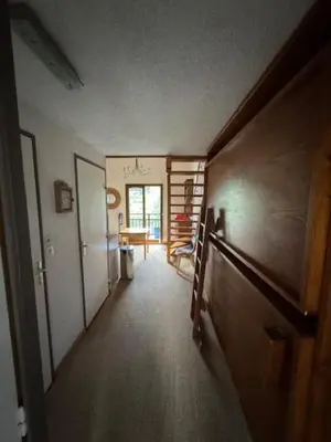 an empty hallway with a room with a door and a staircase at Le chalet des pistes in Demi-Quartier
