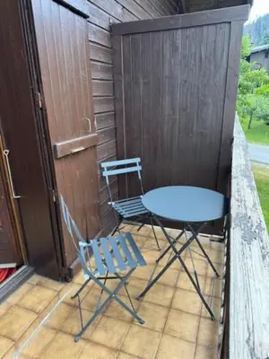 two chairs and a table and a table and chairs on a porch at Le chalet des pistes in Demi-Quartier