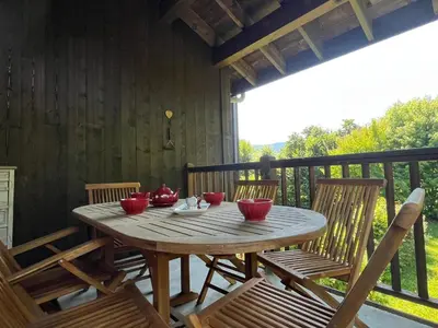 a wooden table and chairs on a porch at T4 Duplex à Samoëns, standing avec balcon & parking privé - FR-1-629-149 in Samoëns