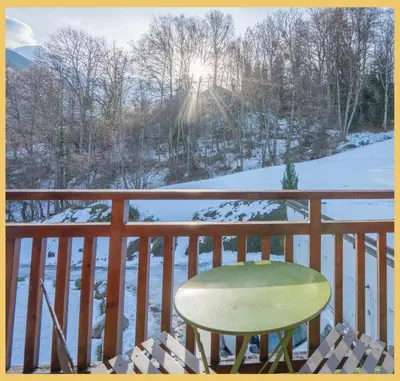 a chair on a balcony with snow on the ground at Studio La Piste Verte I Saint-Gervais in Saint-Gervais-les-Bains