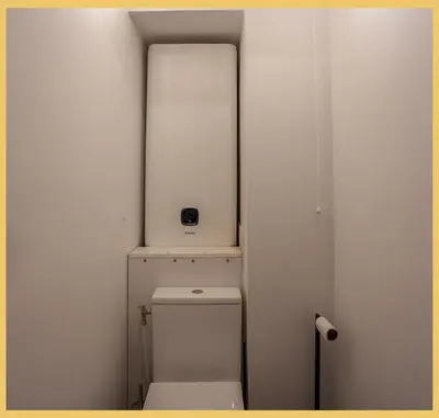a bathroom with a toilet with a shelf above it at Studio La Piste Verte I Saint-Gervais in Saint-Gervais-les-Bains