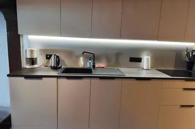 a kitchen counter with a sink and a light at South-facing flat with garden near city center in Saint-Gervais-les-Bains
