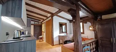 a room with a kitchen and a bed in a house at South-facing flat with garden near city center in Saint-Gervais-les-Bains