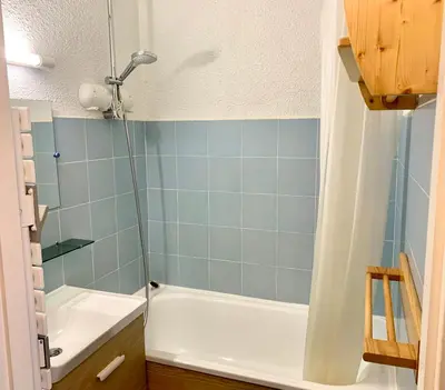 a bathroom with a shower and a tub and a sink at Studio cosy au cœur de la station des Carroz in Arâches-la-Frasse