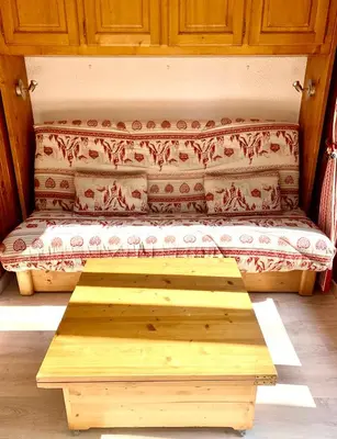 a wooden bench sitting in the middle of a room at Studio cosy au cœur de la station des Carroz in Arâches-la-Frasse