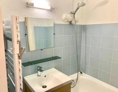 a bathroom with a sink and a mirror at Studio cosy au cœur de la station des Carroz in Arâches-la-Frasse