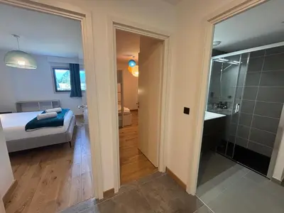 a bedroom with a bed and a bathroom with a shower at Kayla du Mont-Blanc - Espace bien etre - Piscine in Les Houches