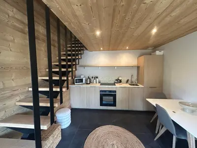 a kitchen with a spiral staircase in a house at 35 m2 duplex in a new 2025 chalet in Saint-Gervais-les-Bains