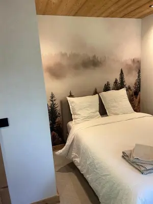 a bedroom with a bed with a painting on the wall at 35 m2 duplex in a new 2025 chalet in Saint-Gervais-les-Bains