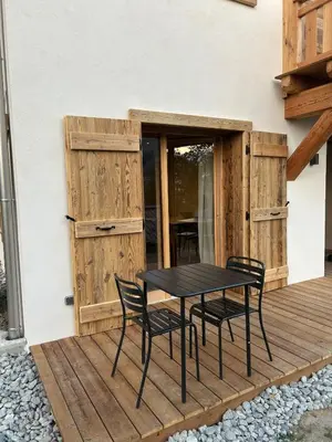 a black table and chairs on a wooden deck at 35 m2 duplex in a new 2025 chalet in Saint-Gervais-les-Bains
