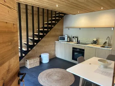 a kitchen with a spiral staircase in a house at 35 m2 duplex in a new 2025 chalet in Saint-Gervais-les-Bains