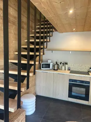 a kitchen with a spiral staircase in a house at 35 m2 duplex in a new 2025 chalet in Saint-Gervais-les-Bains