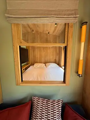 a bedroom with a mirror on the wall with a bed at Chalet Meta by Brennus Chamonix in Chamonix-Mont-Blanc