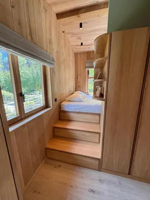 a tiny house with a bed and a window at Chalet Meta by Brennus Chamonix in Chamonix-Mont-Blanc