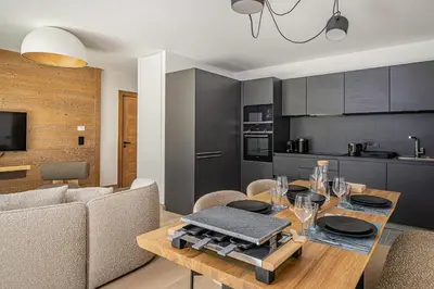 a kitchen and dining room with a table and chairs at Paradisa Cosmique Moderne 2-bedroom with amazing Mont-Blanc view! in Chamonix-Mont-Blanc