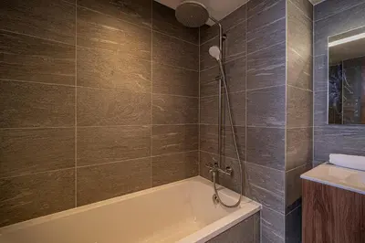a bathroom with a bath tub and a sink at Paradisa Cosmique Moderne 2-bedroom with amazing Mont-Blanc view! in Chamonix-Mont-Blanc
