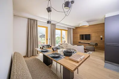 a kitchen and living room with a table and chairs at Paradisa Cosmique Moderne 2-bedroom with amazing Mont-Blanc view! in Chamonix-Mont-Blanc