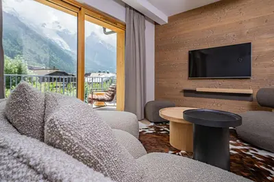 a living room with a couch and a television at Paradisa Cosmique Moderne 2-bedroom with amazing Mont-Blanc view! in Chamonix-Mont-Blanc
