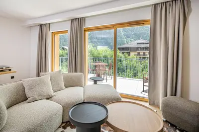 a living room with a couch and a large window at Paradisa Cosmique Moderne 2-bedroom with amazing Mont-Blanc view! in Chamonix-Mont-Blanc