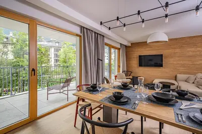 a dining room with a table and a living room at Paradisa Balcon du Géant Elegantly designed 4-bedroom apartment in Chamonix-Mont-Blanc