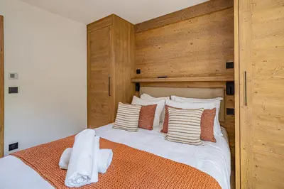 a bedroom with a bed with white sheets and pillows at Paradisa Balcon du Géant Elegantly designed 4-bedroom apartment in Chamonix-Mont-Blanc