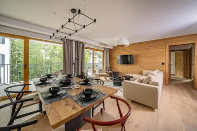 a living room with a large wooden table and chairs at Paradisa Balcon du Géant Elegantly designed 4-bedroom apartment in Chamonix-Mont-Blanc