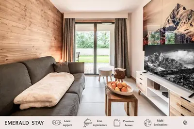 a living room with a couch and a tv at Apartment Alpinea, Les Houches - by EMERALD STAY in Les Houches