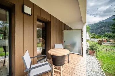 a house with a table and chairs on a deck at Apartment Alpinea, Les Houches - by EMERALD STAY in Les Houches