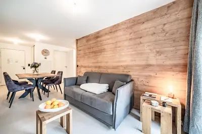 a living room with a couch and a table at Apartment Alpinea, Les Houches - by EMERALD STAY in Les Houches
