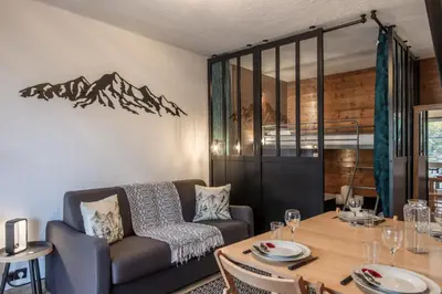 a living room with a table and a couch at La vue du Rosay - Balcon - Vues in Saint-Gervais-les-Bains