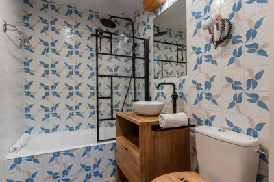a bathroom with blue and white tiled walls and a toilet at La vue du Rosay - Balcon - Vues in Saint-Gervais-les-Bains