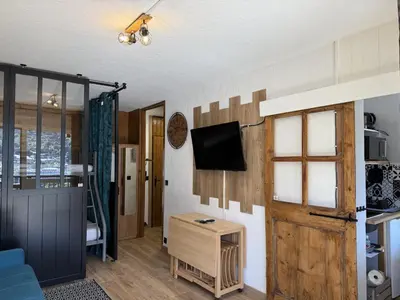 a living room with a tv and a door at La vue du Rosay - Balcon - Vues in Saint-Gervais-les-Bains