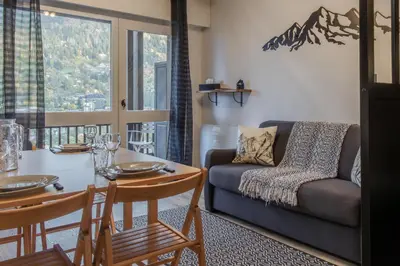 a living room with a couch and a table at La vue du Rosay - Balcon - Vues in Saint-Gervais-les-Bains